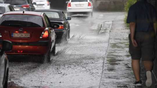 Zaplavená cesta počas búrky a prechádzajúce autá.
