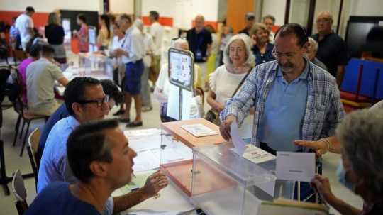 Volič vkladá hlasovací lístok do volebnej schránky počas predčasných parlamentných volieb v španielskom Madride.