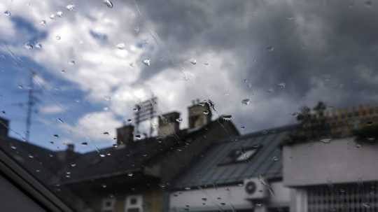 Na snímke kvapky dažďa na strešnom okne domu.