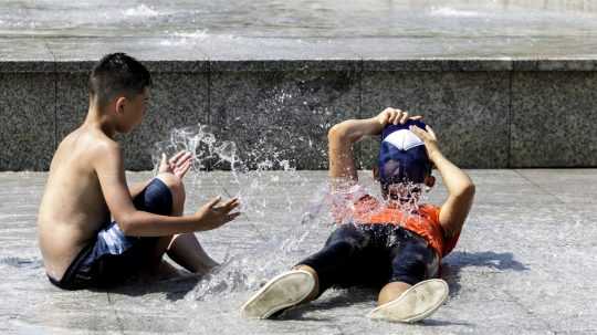 Deti si užívajú horúci letný deň vo fontáne Družba na Námestí slobody v Bratislave.