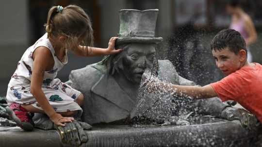 Deti sa ochladzujú vo fontáne počas horúceho letného dňa v centre Trenčína.