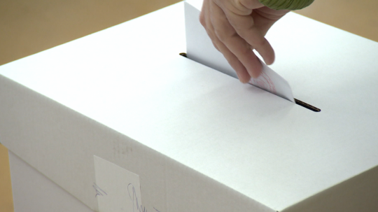 Ilustračná snímka voliča vhadzujúceho hlasovací lístok do volebnej urny.
