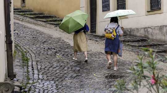 Na snímke ženy s dáždnikmi.