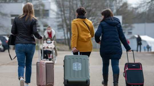 Na archívnej snímke z 18. marca 2022 tri Ukrajiny s kuframi prichádzajú do prijímacieho centra pre utečencov v nemeckom meste Ellwangen.