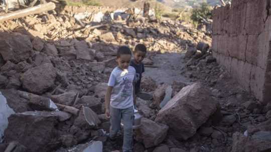Marockí chlapci kráčajú v troskách ich zničeného domu po zemetrasení.