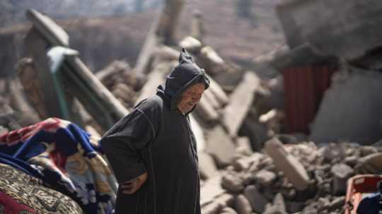 Osoba prechádza ruinami zničenej stavby po zemetrasení v Maroku.