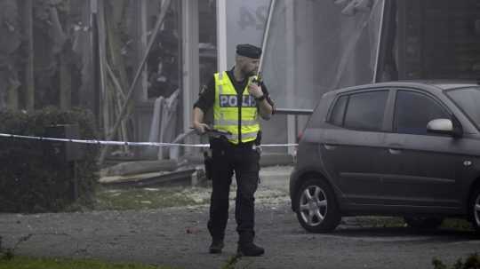 Policajt stojí neďaleko miesta výbuchu vo švédskej Storvrete.