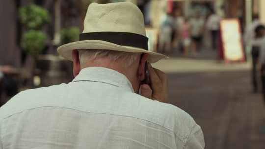 Senior telefonuje na ulici.