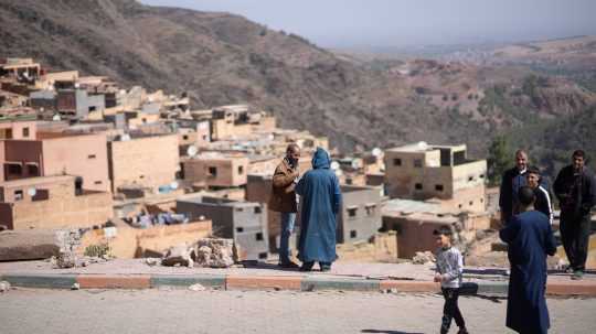 Dedinčania stoja pri troskách zničeného domu po zemetrasení v dedine Moulay Ibrahim.
