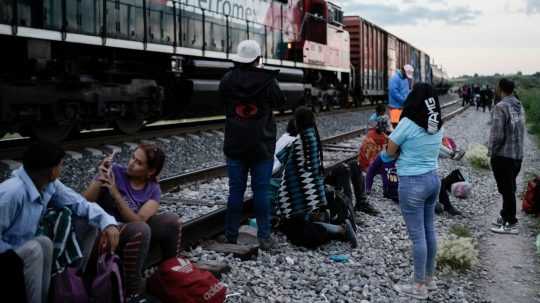 Migranti Z Mexika sledujú ako okolo nich prechádza nákladný vlak smerujúci do USA.