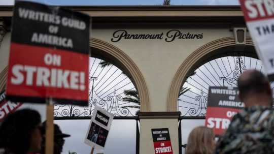 Na snímke demonštranti kráčajú s nápismi počas zhromaždenia pred štúdiom Paramount Pictures.