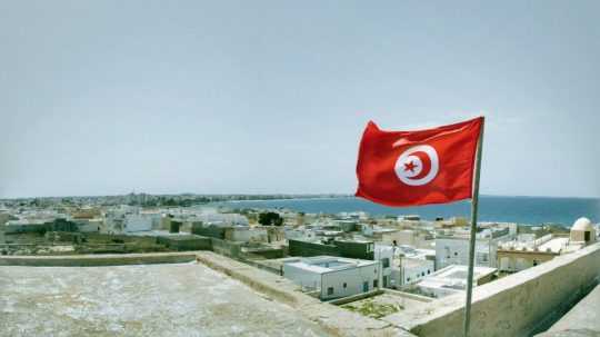 Na snímke vlajka Tuniska s pozadím krajiny.