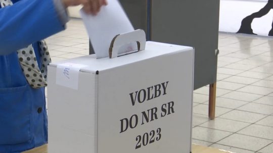 Volička vhadzuje obálku do volebnej urny.
