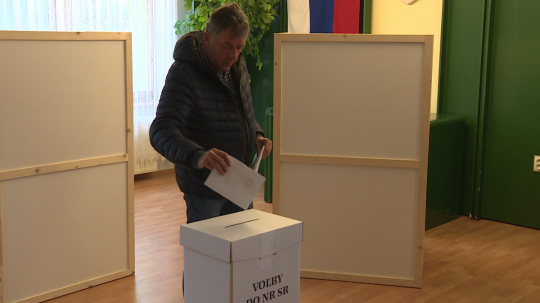 Volič pri vhadzovaní obálky s hlasovacím lístkom do volebnej urny.