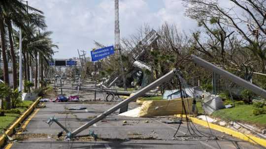 Strhnuté elektrické stĺpy a vedenie po hurikáne Otis.