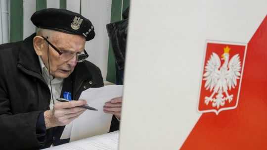 Na snímke si muž pripravuje svoj volebný lístok počas poľských parlamentných volieb v októbri 2023.