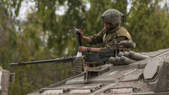 Izraelský vojak pracuje na tanku pri hraniciach s pásmom Gazy.