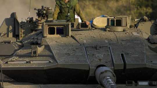Izraelský vojak prichádza s tankom do oblasti nasadenia neďaleko hraníc s Libanonom.
