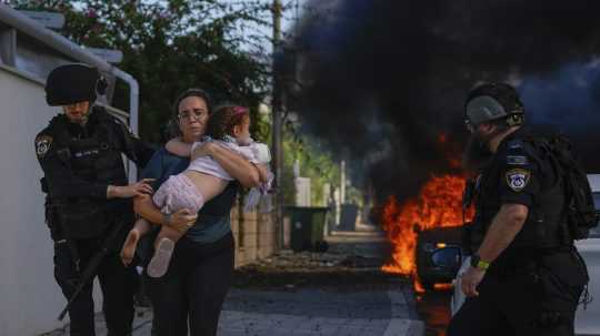 Polícia evakuuje ženu s dieťaťom z pásma Gazy.