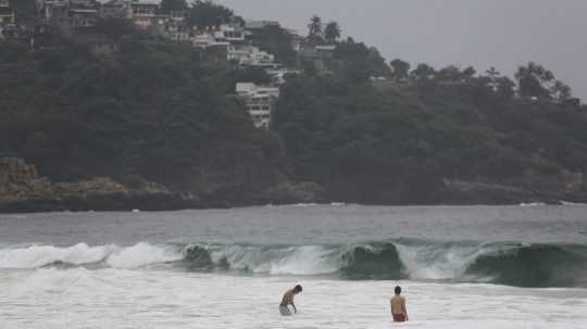 Turisti plávajú v letovisku Acapulco pred príchodom hurikánu Otis.