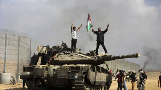 Palestínčania oslavujú pri zničenom izraelskom tanku na juhu pásma Gazy.