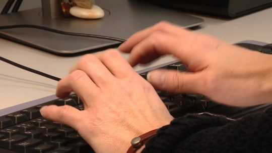 na snímke muž píše na klávesnici počítača