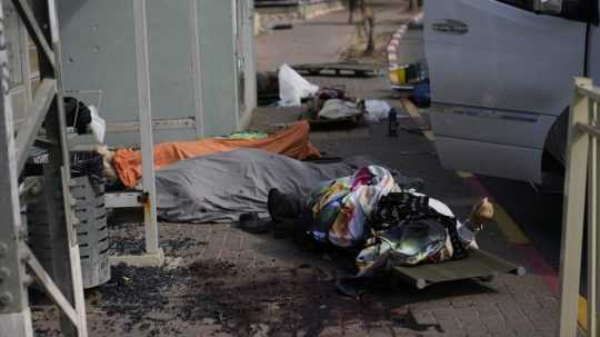 Izraelskí civilisti zabití pri palestínskom raketovom útoku z pásma Gazy ležia zakrytí na zastávke v meste Sderot na juhu Izraela.