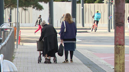 Na snímke dôchodkyňa a žena kráčajú na ulici.