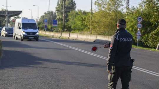 Na snímke slovenský policajt zastavuje dodávku počas náhodných kontrol.