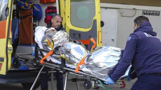 Záchranári prevážajú do nemocnice človeka, ktorý prežil stroskotanie lode.