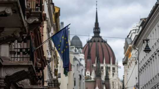 Vlajka Európskej únie na budove v centre Budapešti, v pozadí budova parlamentu Maďarska.