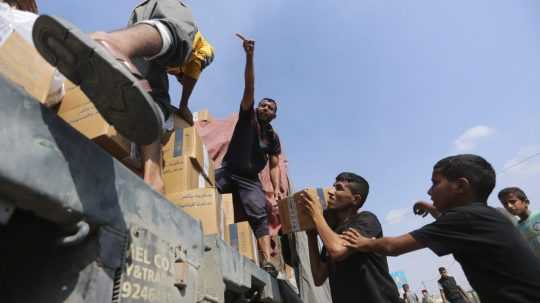 Palestínčania rabujú nákladné auto s humanitárnou pomocou.