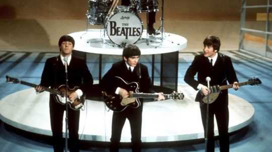 Na archívnej snímke z 9. februára 1964 členovia anglickej skupiny The Beatles v popredí zľava Paul McCartney, George Harrison, John Lennon.