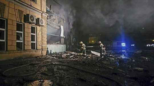 Ukrajinskí hasiči na archívnej snímke zasahujú na mieste ruského raketového útoku na Odesu.