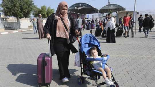Palestínčania prechádzajú na egyptskú stranu hranice s pásmom Gazy.