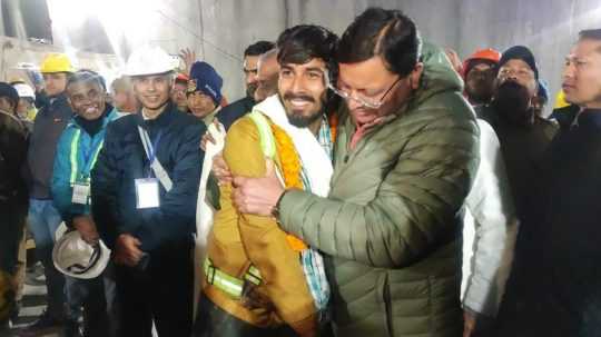 Hlavný minister štátu Uttarákhand Pushkar Singh Dhami (vpravo) víta zachráneného robotníka.