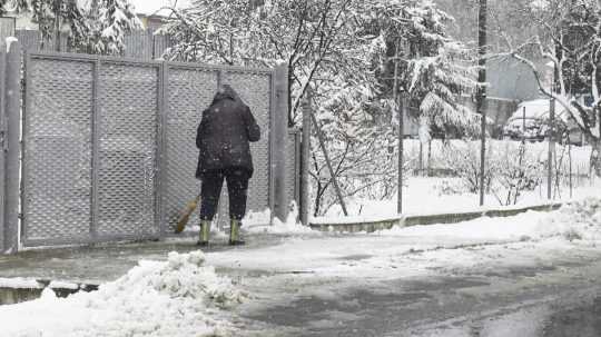 Na snímke obyvateľka odhrabáva sneh z chodníka v obci Skároš v okrese Košice okolie 6. apríla 2023.