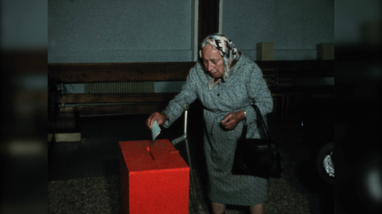 Sn=imka z volieb do národných výborov. Dôchodkyňa vhadzuje lístok do volebnej urny.
