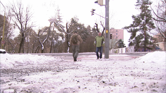 Na snímke muži v Košiciach prechádzajú cez cestu po svetelnej križovatke.