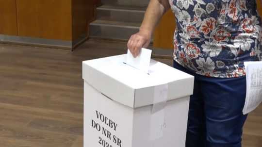 Na snímke staršia žena vhadzuje do volebnej urny volebný lístok.