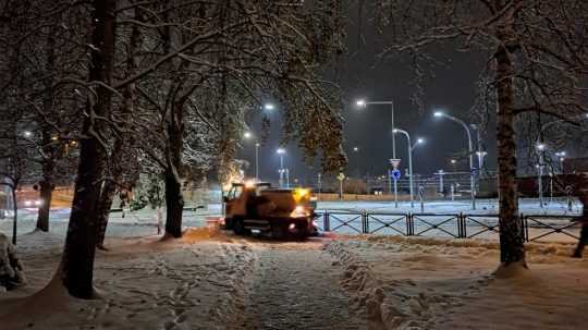Zamrznutý chodník a sypač na ulici v Poprade.