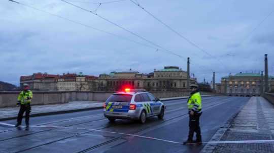 Na snímke policajti hliadkujú po streľbe v centre Prahy.