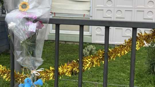 Kvety položené pri bráne budovy, kde boli nájdené štyri zabité deti vo veku od 9 mesiacov do 10 rokov a ich matka.