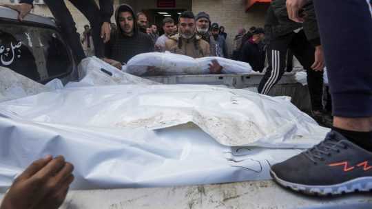 Palestínčania nakladajú do nákladného auta telá svojich príbuzných.