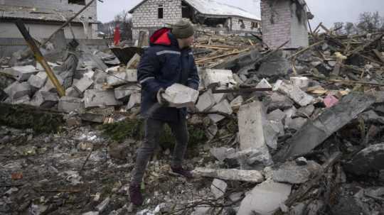 Miestny obyvateľ odstraňuje trosky na mieste domu zničeného pri pondelkovom (11. 12.) ruskom raketovom útoku na Kyjev.