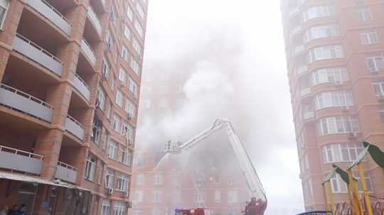 Hasiči sa snažia uhasiť požiar v požkodenej obytnej budove v ukrajinskej Odese.