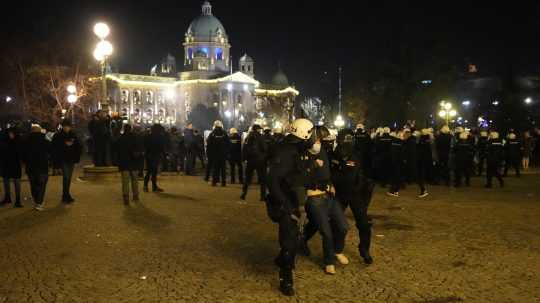Príslušníci srbských poriadkových síl zatýkajú demonštranta počas zrážok v centre Belehradu
