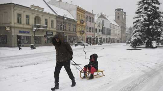 Na snímke žena vezie dieťa na saniach počas sneženia v centre Košíc.