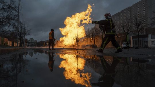 Hasič pracuje na hasení požiaru plynového potrubia poškodeného ruským raketovým útokom v Kyjeve.