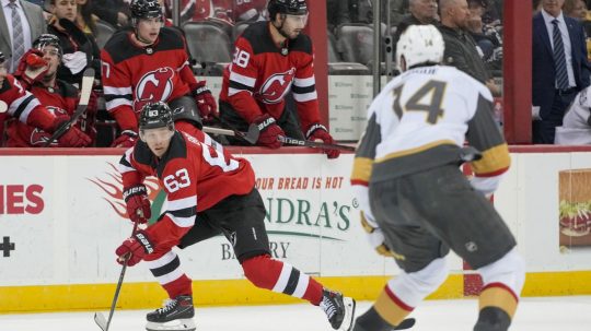 Slovenský hokejista v drese New Jersey Devils Šimon Nemec (uprostred v pozadí) sleduje zo striedačky zápas zámorskej NHL New Jersey Devils - Vegas Golden Knights.